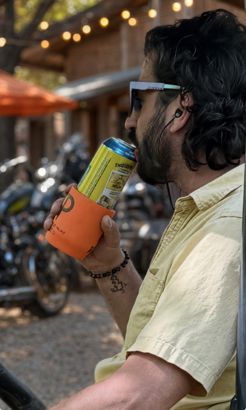 Little Andy holding a drink near motorcycles